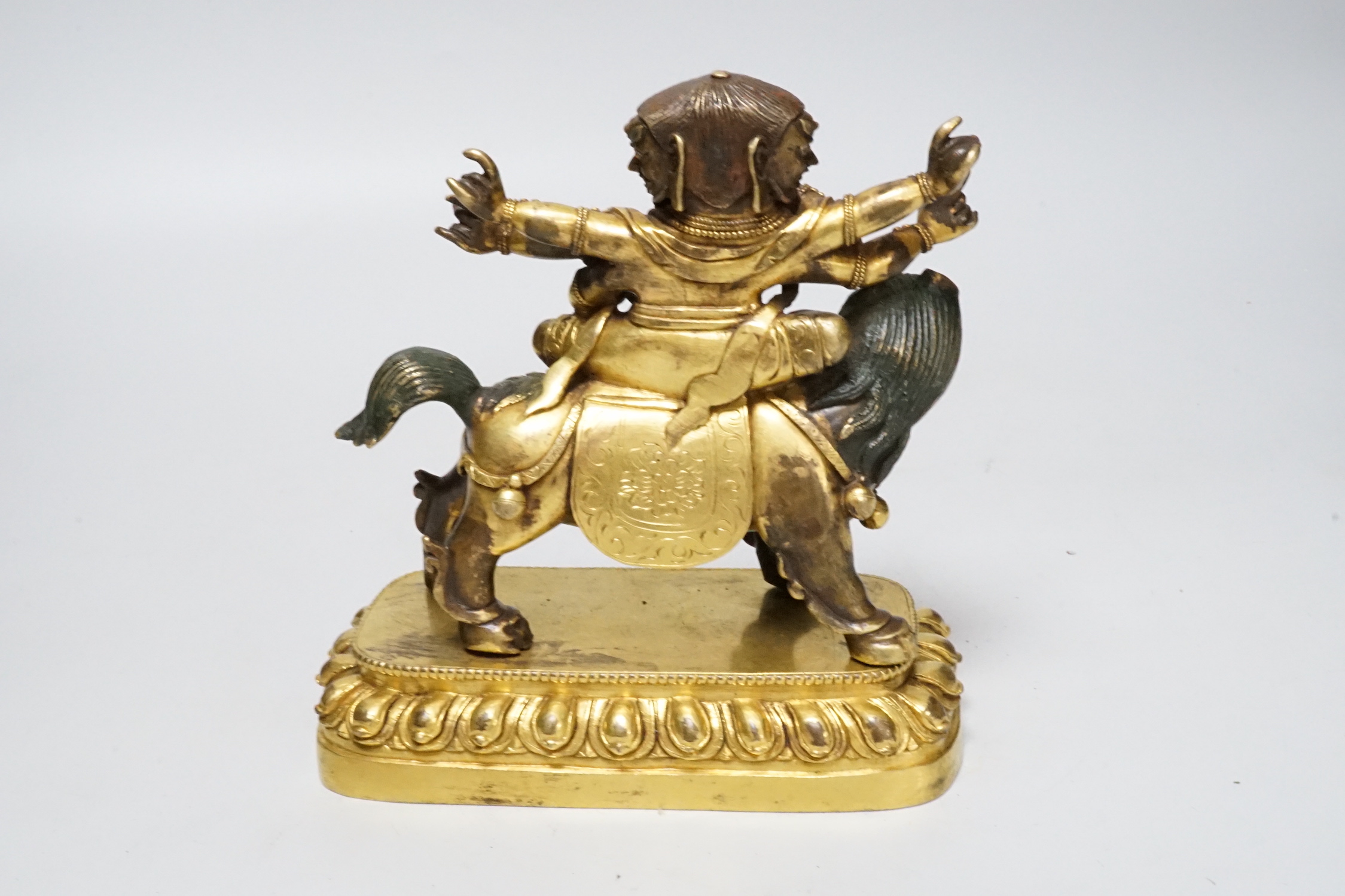 A Sino-Tibetan gilt bronze group of a deity on lionback, 15cm wide